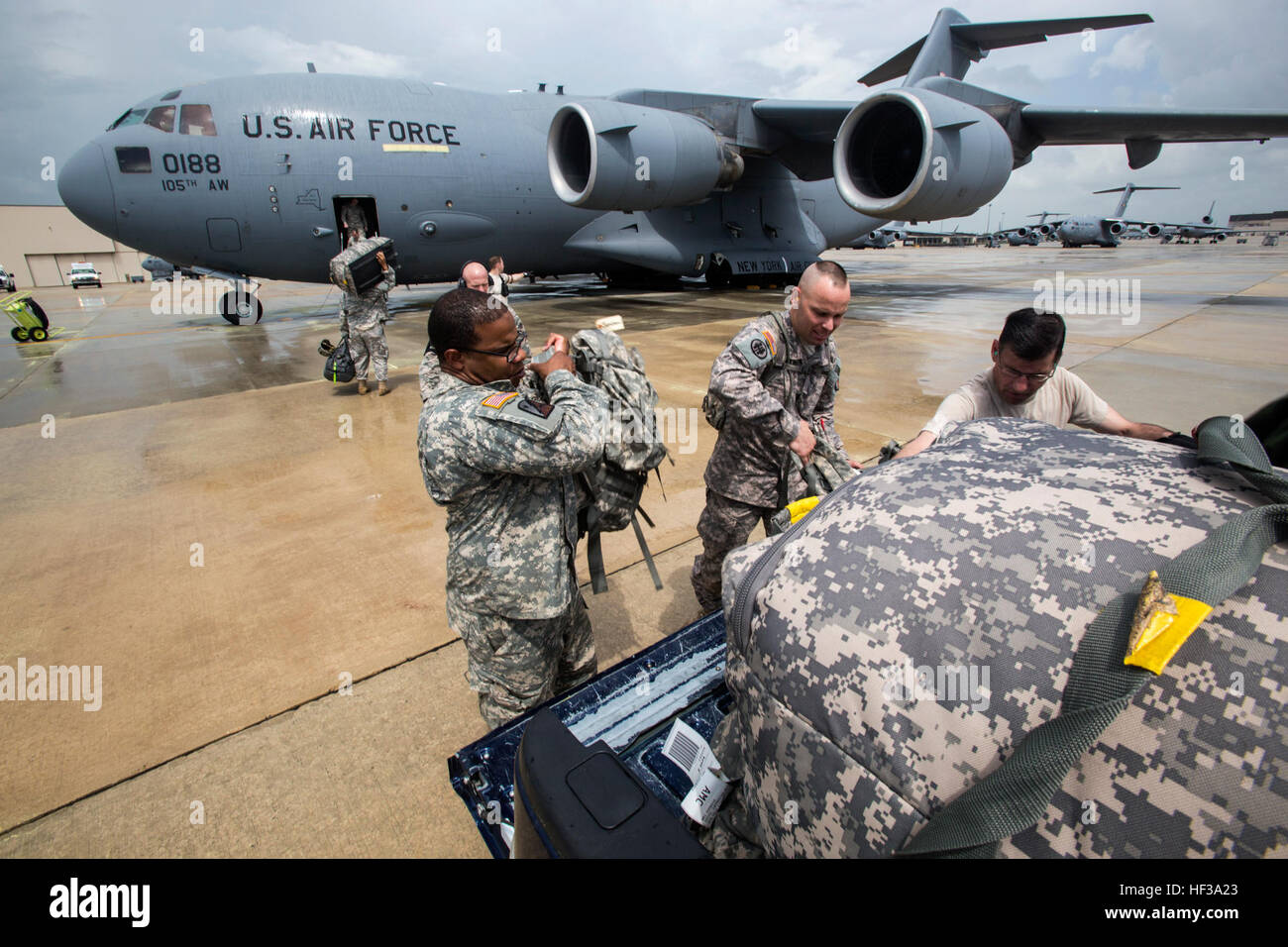 Soldats avec le Siège de l'entreprise et de l'Administration centrale, 50ème Infantry Brigade Combat Team, New Jersey Army National Guard, charger l'équipement personnel sur un C-17 Globemaster III de la New York Air National Guard's 105th Airlift Wing pendant un exercice de déploiement à Joint Base McGuire-Dix-Lakehurst, N.J., le 11 mai 2015. L'exercice, une partie de l'unité de formation annuel, était de tester la capacité de transport de l'IBCT 50e. (U.S. Air National Guard photo par le Sgt. Mark C. Olsen/NJNG) Parution véhicules de charge et les soldats sur le C-17 150511-AL-Z508-084 Banque D'Images