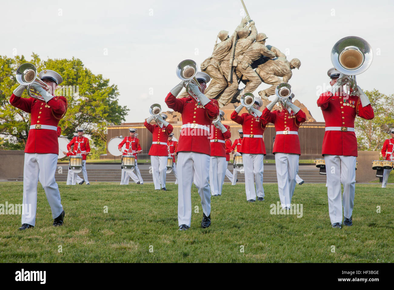 Les Marines américains avec le Corps des Marines américains Drum and Bugle Corps effectuer pendant le coucher du soleil à la parade Marine Corps War Memorial, Arlington, Va., 26 mai 2015. Depuis septembre 1956, défilé et encore de machines de la caserne de la Marine à Washington, D.C., ont été rendre hommage à ceux qui est 'rare bravoure était une vertu commune' en présentant des parades au coucher du soleil dans l'ombre de la 32 pieds de haut chiffres de l'United States Marine Corps War Memorial. (U.S. Marine Corps photo par Lance Cpl. Alejandro Sierras/libérés) Coucher de Parade 150526-M-GK605-181 Banque D'Images
