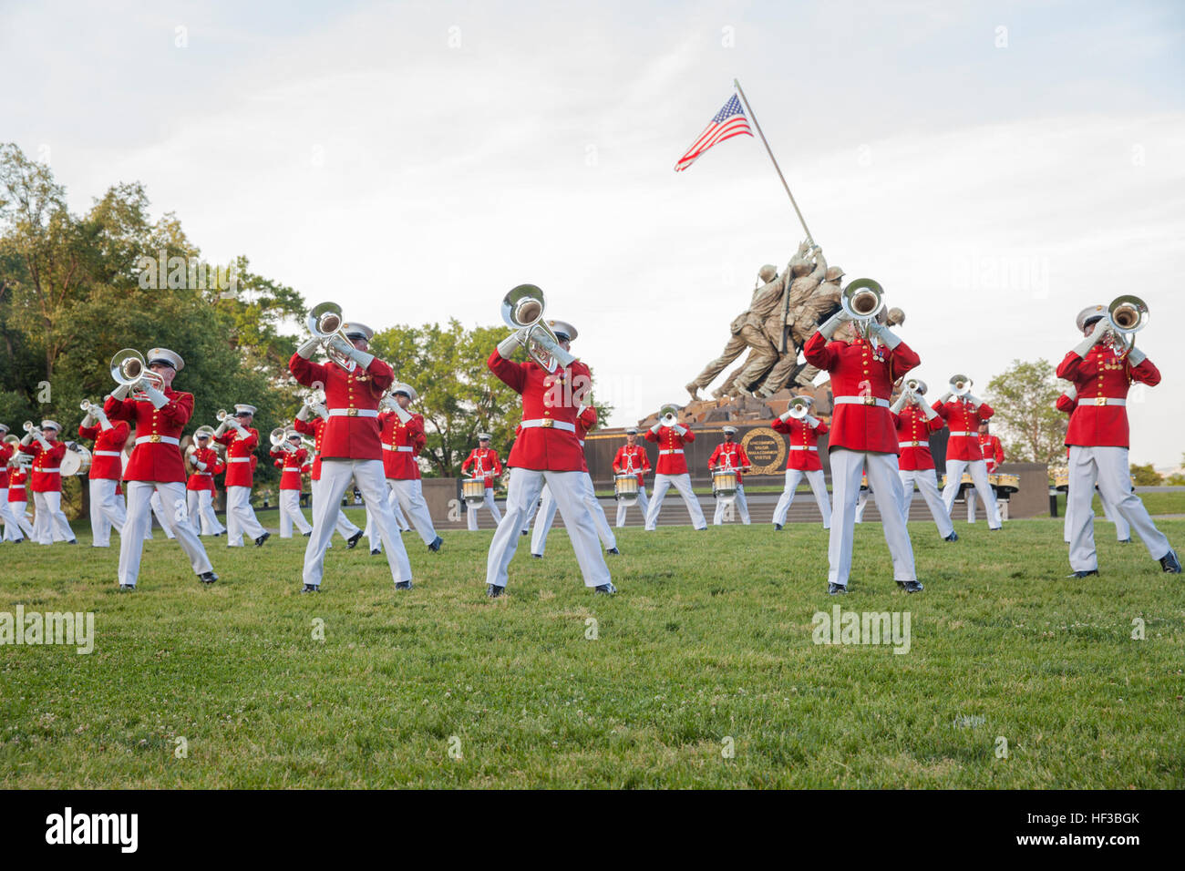 Les Marines américains avec le Corps des Marines américains Drum and Bugle Corps effectuer pendant le coucher du soleil à la parade Marine Corps War Memorial, Arlington, Va., 26 mai 2015. Depuis septembre 1956, défilé et encore de machines de la caserne de la Marine à Washington, D.C., ont été rendre hommage à ceux qui est 'rare bravoure était une vertu commune' en présentant des parades au coucher du soleil dans l'ombre de la 32 pieds de haut chiffres de l'United States Marine Corps War Memorial. (U.S. Marine Corps photo par Lance Cpl. Alejandro Sierras/libérés) Coucher de Parade 150526-M-GK605-222 Banque D'Images