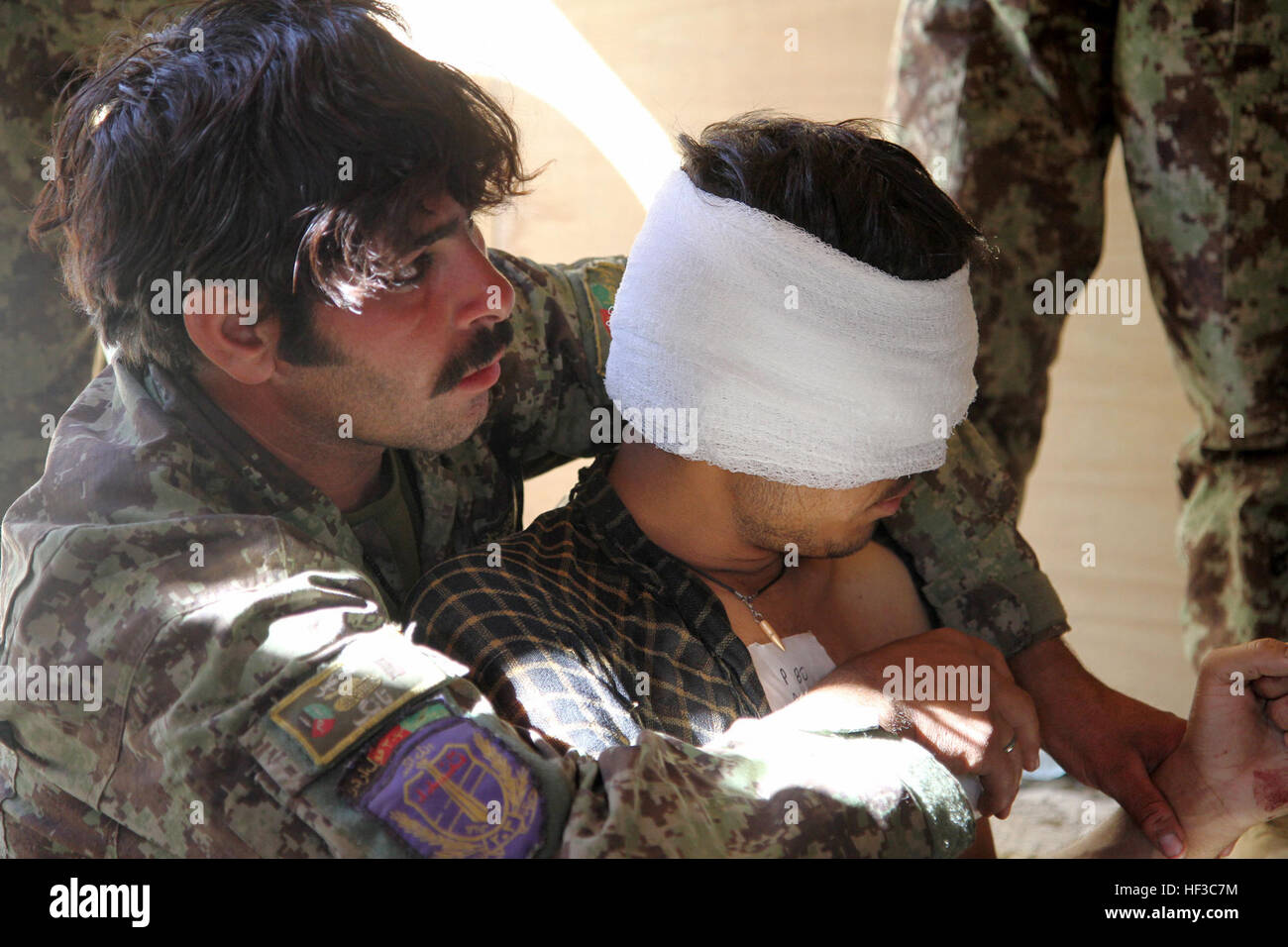 L'Armée nationale afghane Pvt. Muhammed Din, combattre gareautrain, 3e Kandak, 2e Brigade, 203e Corps, soutient un combat pour qu'il puisse respirer plus facilement à l'avant poste Zerok 23 Mai, 2013. Infirmiers de l'ANA a pris l'initiative sur les soins de première intervention lors de l'opération Zafar, une patrouille de sécurité de 10 jours dans le district de Nikeh. Les forces américaines ont accompagné la ANA comme conseillers durant la mission. (U.S. Photo de la Garde nationale par la CPS. Mark VanGerpen, 129e Détachement des affaires publiques mobiles) infirmiers de l'ANA se diriger sur première réponse 130523-Z-LN227-130 Banque D'Images