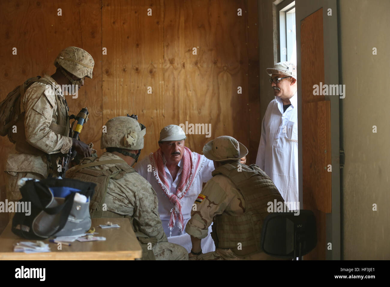 Bataillon de logistique de combat des marines avec 1, 1 Régiment de logistique de combat, d'interagir avec un acteur agissant comme un aîné du village afin d'obtenir des renseignements sur les mouvements ennemis dans la région au cours de l'exercice à grande échelle 15 à bord Marine Corps Air Ground Combat Center Twentynine Palms, Californie, le 18 août 2015. LSE-15 est une combinaison d'un Corps des Marines américains, canadiens et britanniques, mené au niveau de la brigade, qui vise à permettre à vivre, virtuelle et constructive pour la formation des forces canadiennes participantes. (U.S. Marine Corps photo par Lance Cpl. Chris Garcia/libérés) BEC 1 MOUT effectue la formation dans le cadre Banque D'Images