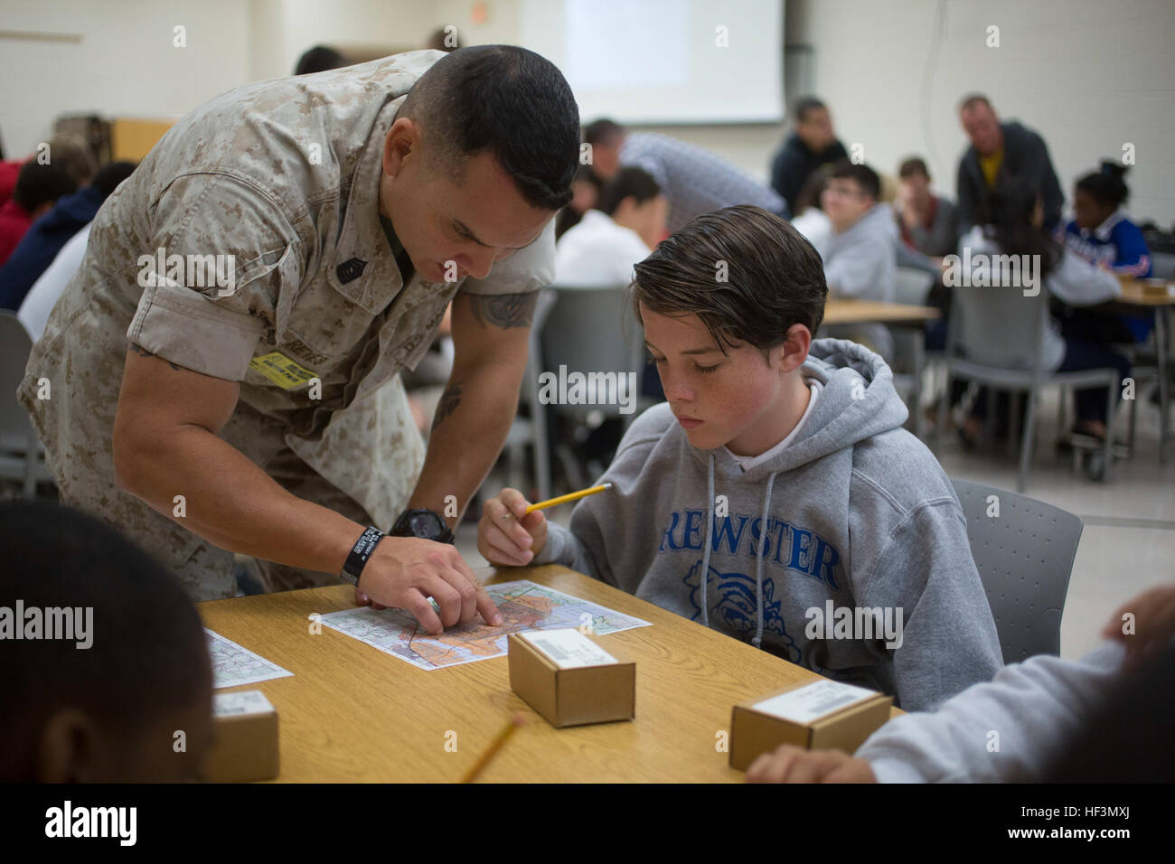 Le sergent-chef du Corps des Marines des États-Unis. Orlando Reyes, S-4, chef de l'école, aide Infantry-East aide un élève tracer des points sur une carte de terrain de base au cours d'une navigation en Brewster Middle school, Camp Lejeune, N.C., 27 octobre, 2015. Marines avec soi-est la classe d'étudiants afin de les aider à mieux comprendre certaines des compétences que leurs parents utilisent dans le Corps des Marines. (U.S. Marine Corps photo par soi-est de Caméra de combat, le Cpl. Andrew/Kuppers) Parution Marines avec soi-est de fournir des terrains de base de cours de navigation à Brewster Middle School Students 151027-M-NT768-005 Banque D'Images Le sergent-chef du Corps des Marines des États-Unis. Orlando Reyes, S-4, chef de l'école, aide Infantry-East aide un élève tracer des points sur une carte de terrain de base au cours d'une navigation en Brewster Middle school, Camp Lejeune, N.C., 27 octobre, 2015. Marines avec soi-est la classe d'étudiants afin de les aider à mieux comprendre certaines des compétences que leurs parents utilisent dans le Corps des Marines. (U.S. Marine Corps photo par soi-est de Caméra de combat, le Cpl. Andrew/Kuppers) Parution Marines avec soi-est de fournir des terrains de base de cours de navigation à Brewster Middle School Students 151027-M-NT768-005 Banque D'Images