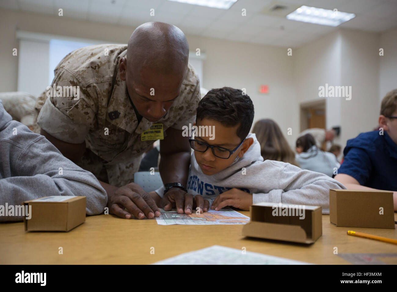 Premier sergent du Corps des Marines des États-Unis. Johnathan D. pensionnaires, première société Sergent, Compagnie d'hôtel, de formation de combat maritime, école de bataillon Infantry-East (SOI-est), aide son fils Esaïe plot points sur une carte de terrain de base au cours d'une navigation en Brewster Middle school, Camp Lejeune, N.C., 27 octobre, 2015. Marines avec soi-est la classe d'étudiants afin de les aider à mieux comprendre certaines des compétences que leurs parents utilisent dans le Corps des Marines. (U.S. Marine Corps photo par soi-est de Caméra de combat, le Cpl. Andrew/Kuppers) Parution Marines avec soi-est de fournir des terrains de base de cours de navigation à Brewster Midd Banque D'Images Premier sergent du Corps des Marines des États-Unis. Johnathan D. pensionnaires, première société Sergent, Compagnie d'hôtel, de formation de combat maritime, école de bataillon Infantry-East (SOI-est), aide son fils Esaïe plot points sur une carte de terrain de base au cours d'une navigation en Brewster Middle school, Camp Lejeune, N.C., 27 octobre, 2015. Marines avec soi-est la classe d'étudiants afin de les aider à mieux comprendre certaines des compétences que leurs parents utilisent dans le Corps des Marines. (U.S. Marine Corps photo par soi-est de Caméra de combat, le Cpl. Andrew/Kuppers) Parution Marines avec soi-est de fournir des terrains de base de cours de navigation à Brewster Midd Banque D'Images