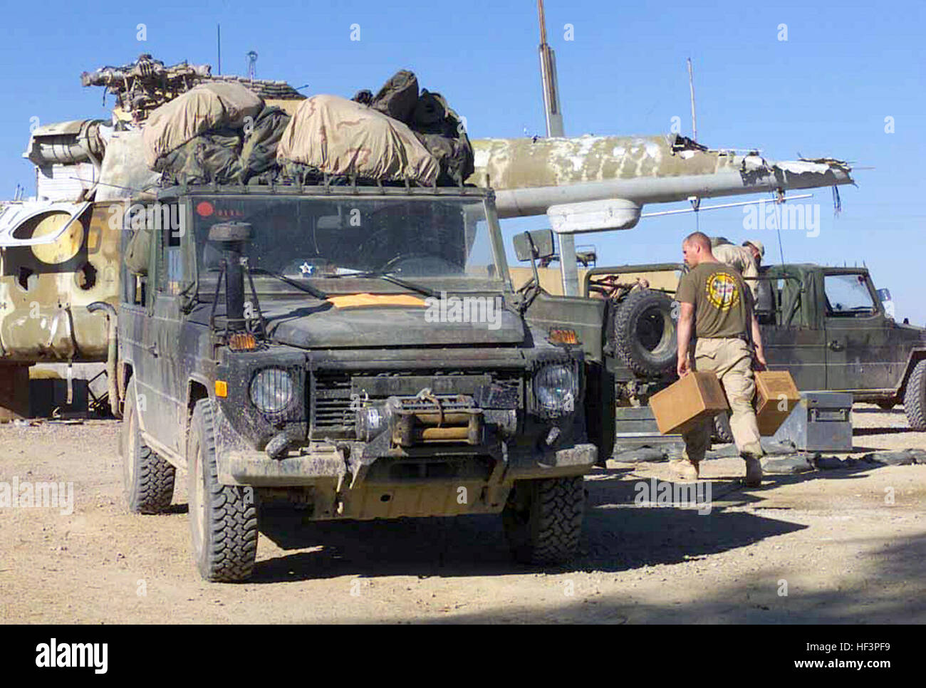 Marines avec 2e Bataillon de Génie de Combat, l'Équipe de débarquement du bataillon 3/6, 26e Marine Expeditionary Unit (Special Operations Capable) de charger leurs Mercedes G IFAV (véhicule d'attaque rapide provisoire) en préparation à leur chiffre d'affaires site bivouac des soldats de l'armée à de la 101e Division d'assaut aérien de l'aéroport international de Kandahar, Kandahar, Afghanistan, au cours de l'opération ENDURING FREEDOM. Dans l'arrière-plan sont les vestiges d'un Mi-18 Hip (H) hélicoptère soviétique. L'USMC Véhicule d'attaque rapide (IFAV)2. Banque D'Images