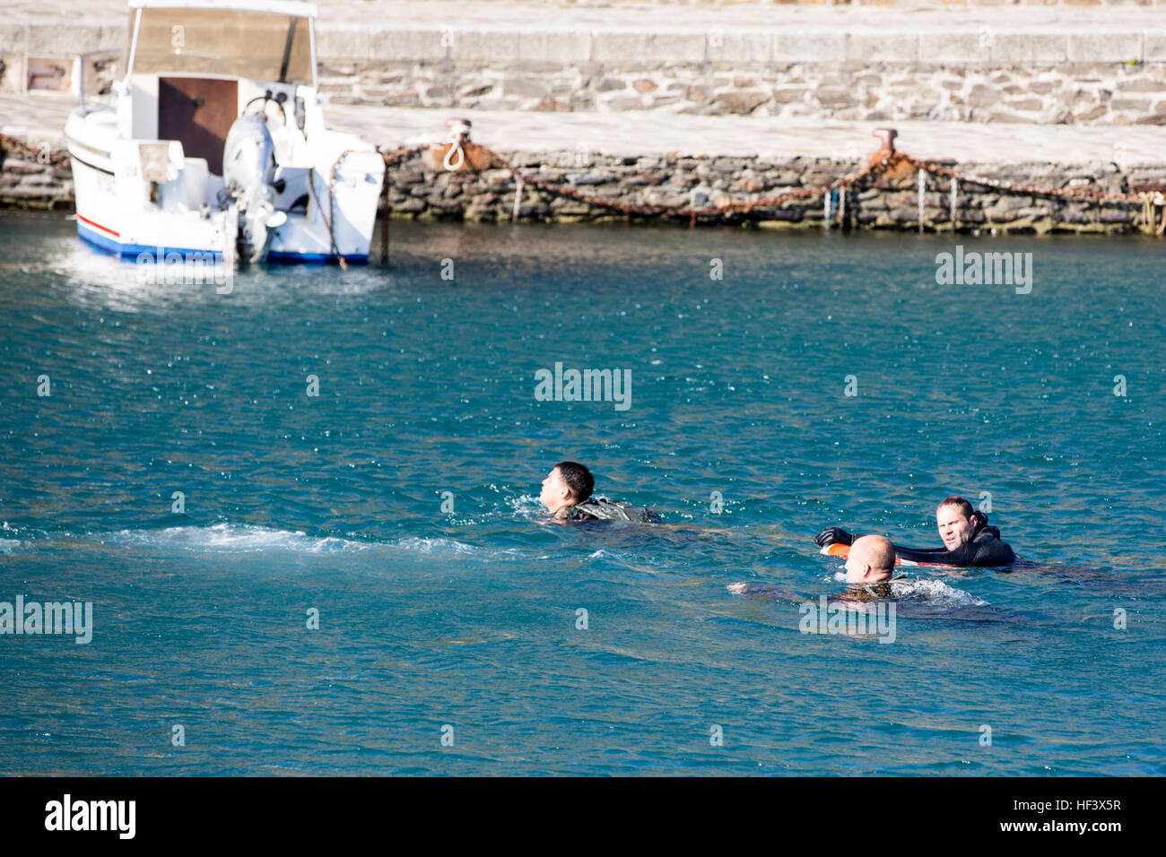 Un commando français instructeur de formation avec le centre d'entraînement Commando national assure la sécurité des Corps des Marines américains Le s.. William J. Miller, sergent de section et le Cpl. Michael A. Martin Jr., chef d'équipe, tant avec la compagnie Bravo, 1er Bataillon, 8e Régiment de Marines, air-sol marin à des fins particulières comme Response-Africa Force-Crisis Tâche ils nager jusqu'au rivage au cours d'un commando français parcours aquatique à Collioure, France, Avril 7, 2016. Le commando français permet la formation SPMAGTF-CR-AF Marines pour former aux côtés des forces françaises et de l'échange de connaissances ainsi que de construire un partenariat que l'ait Banque D'Images