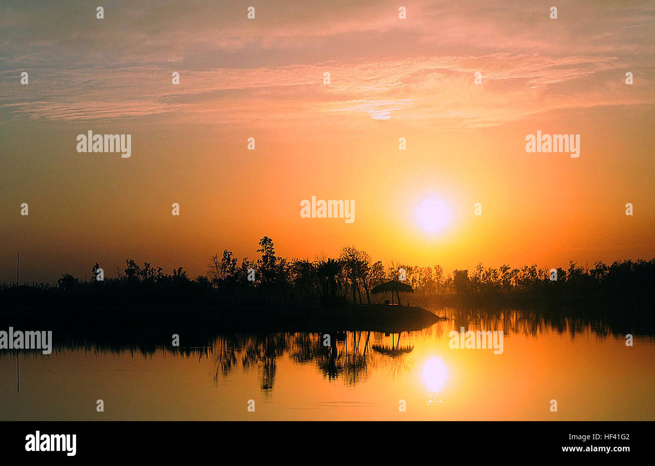 L'établissement Sun offre un décor coloré, silhouetting un abri soleil au lac Z au camp Liberty, l'Iraq, le 11 février. De nombreux soldats disent que les couchers de soleil colorés sont un de leurs choses préférées au sujet d'être stationné au camp de la liberté. Flickr - DVIDSHUB -, l'un des couchers de soleil irakien préféré des soldats d'expérience Banque D'Images