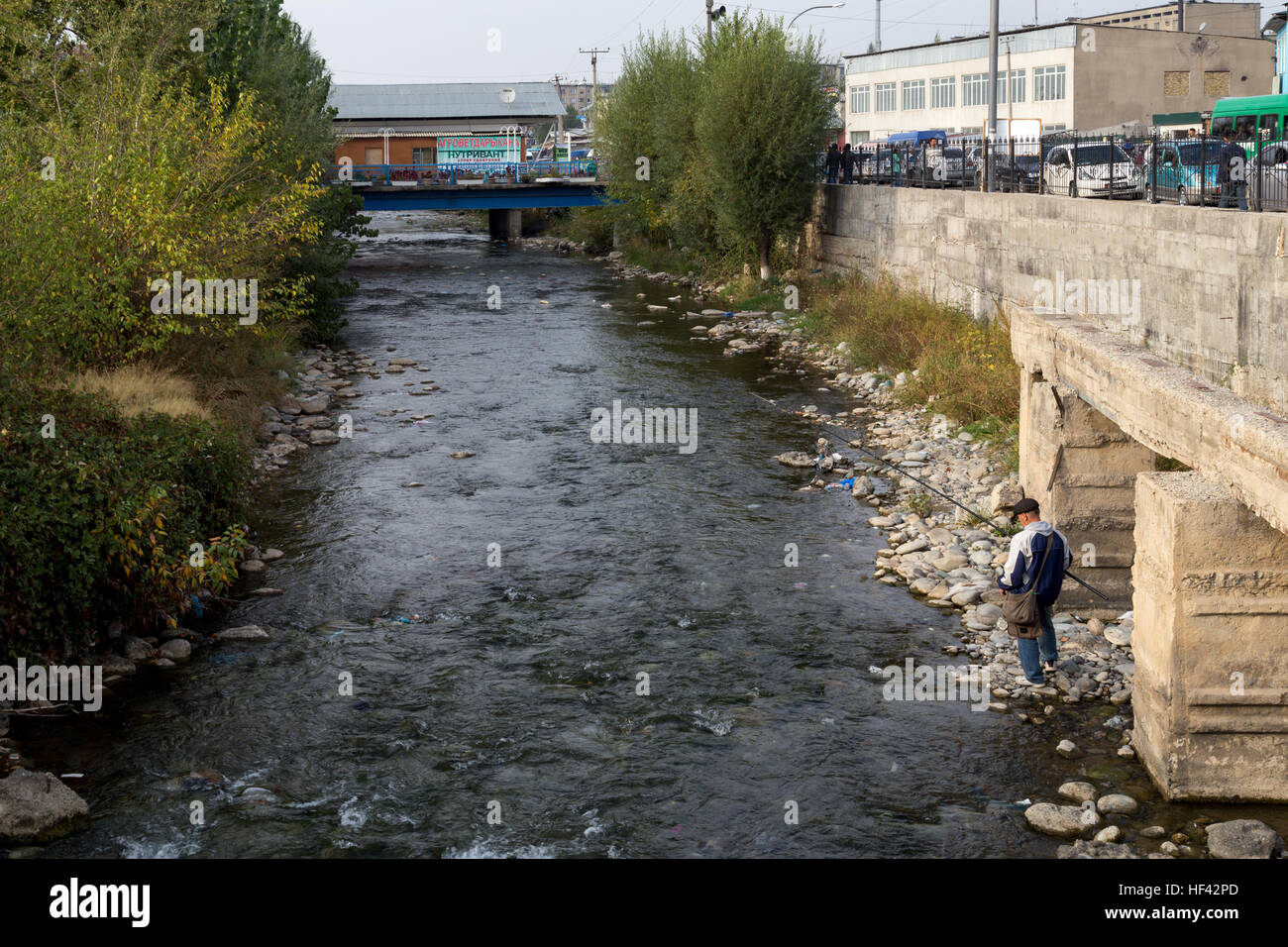 Osh, au Kirghizistan - Octobre 05, 2014 : un pêcheur La pêche dans une rivière de la ville kirghize Osh Banque D'Images