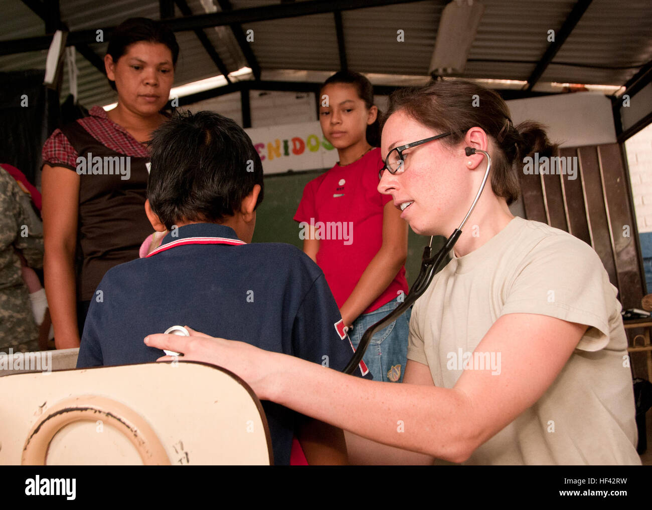 Air Force Le Capitaine Alicia Prescott, 959th groupe médical pédiatre, Lackland Air Force Base, examine un jeune enfant pendant une clinique ici, le 15 avril, pendant au-delà de l'Horizon-El Salvador comme sa famille. Prescott est ici avec une équipe de fournisseurs de soins de santé du Canada, de la Colombie, et les États-Unis qui vont travailler ensemble pendant cinq jours dans Caluco le traitement des patients atteints de diverses maladies et affections. Au-delà de l'horizon est une U.S. Southern Command-parrainé, l'armée sud-led, joint-interaction militaire étrangère et de l'exercice humanitaire avec le service actif, Garde nationale et les membres du service de réserve Banque D'Images