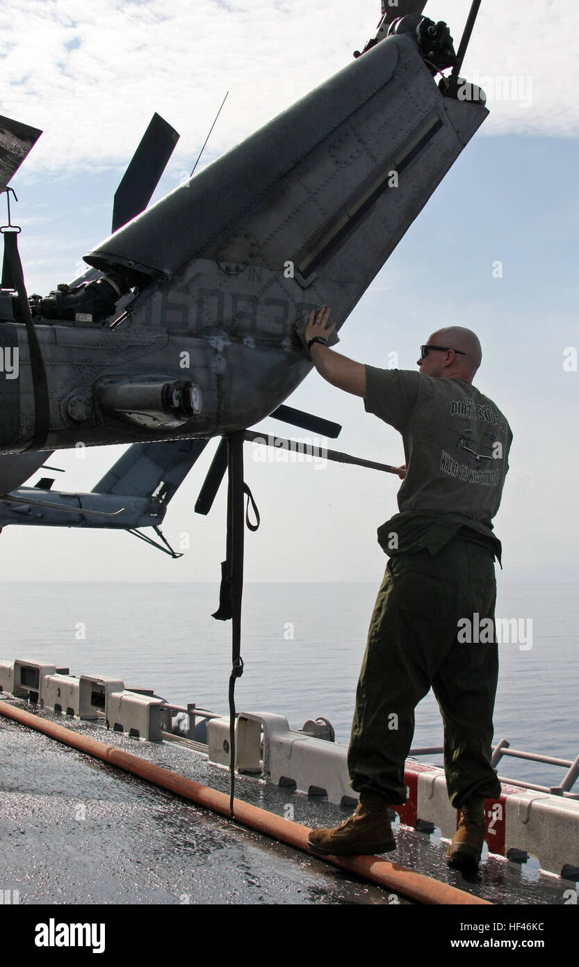 Le Sgt. Kevin P., un technicien de l'aviation d'artillerie lourde de l'Escadron d'hélicoptères maritimes 461 (renforcé), 22e Marine Expeditionary Unit, natif de Cahokia, Ill., lave la queue d'un hélicoptère Huey UH-1N au cours d'un laver sur l'envol du USS Bataan, le 18 mars. Le Laver est un processus standard pour empêcher l'étranger, de l'agriculture et des organismes de contaminer les États-Unis les dirigeants locaux avec le Gouvernement haïtien, l'Organisation des Nations Unies et organisations non gouvernementales ont pris plus de responsabilités principales de l'aide humanitaire et les opérations de secours autour de Haïti. Mar Banque D'Images