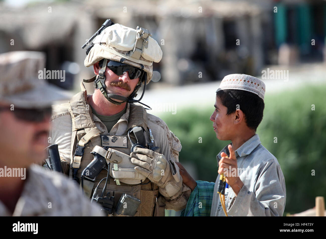 Le sergent d'artillerie de la Marine américaine. Mike Brown, sécurité, 1er Bataillon, 3e Régiment de Marines, parle à l'un des enfants afghans locaux à un bazar à Nawa, en Afghanistan, où la Marine américaine Brig. Le général Joseph L. Osterman, général commandant la 1 Division de marines Foward (1er MarDiv (FWD), était en visite, le 18 avril 2010. Le brig. Le général Osterman était là pour participer à la ré-ouverture d'un bâtiment de l'administration du district, récemment rénové, à l'appui de la Force internationale d'assistance. (U.S. Photo par marines SSgt. Ézéchiel R. Kitandwe /libéré) U.S. Marine Brigue. Le général Joseph Osterman, Nawa Visiter DV Banque D'Images