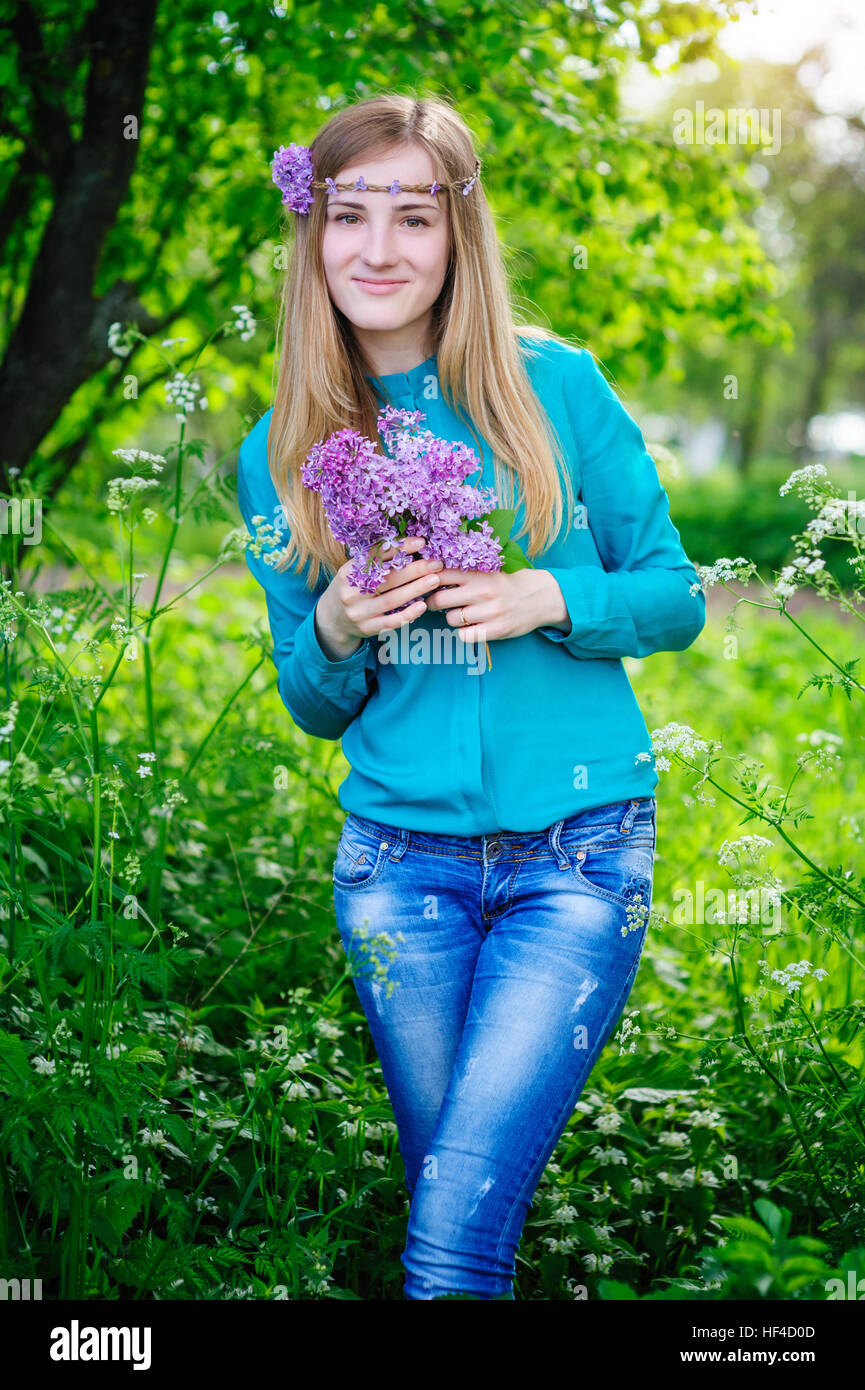 Belle jeune femme avec un bouquet de lilas en mains Jardin de printemps Banque D'Images