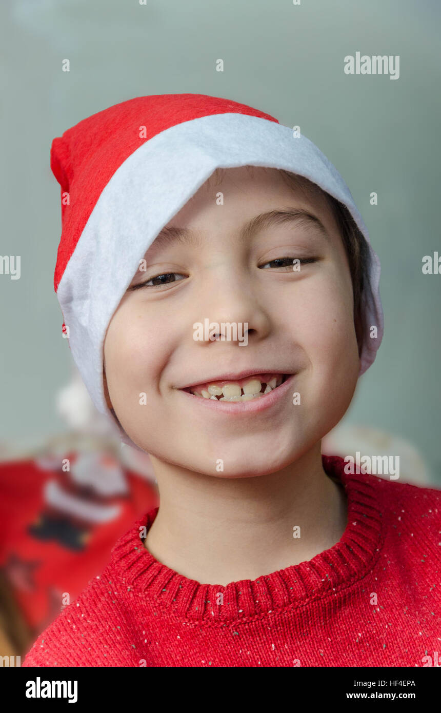 Un portrait d'un jeune garçon portant un chapeau de Père Noël. Banque D'Images