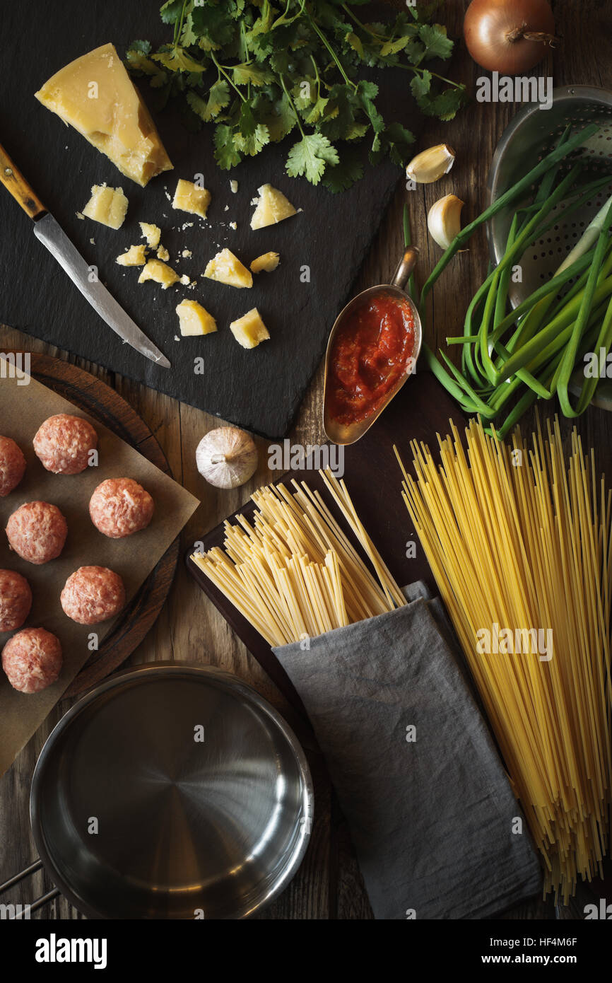 Ingrédients pour la cuisson des spaghettis, des boulettes de fromage et d'herbes fraîches vue supérieure verticale Banque D'Images