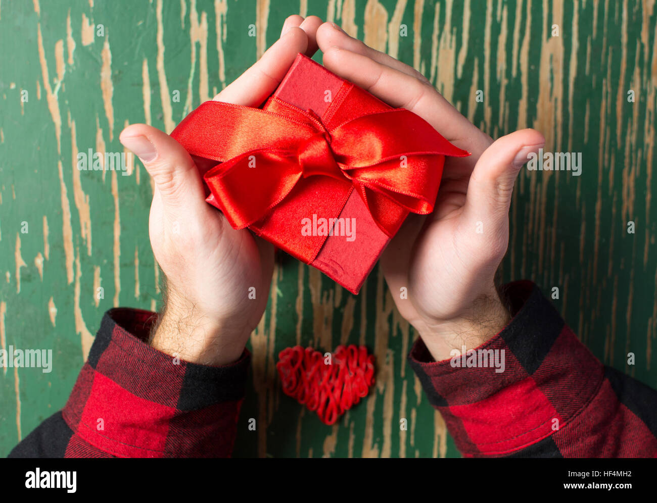 Male hands holding a red Valentines présent fort Banque D'Images