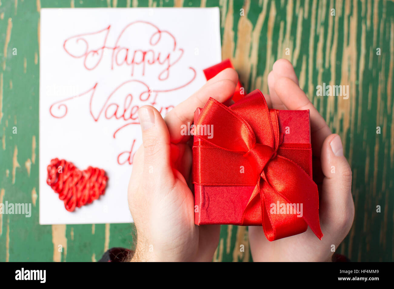 Male hands holding a red Valentines présent fort Banque D'Images