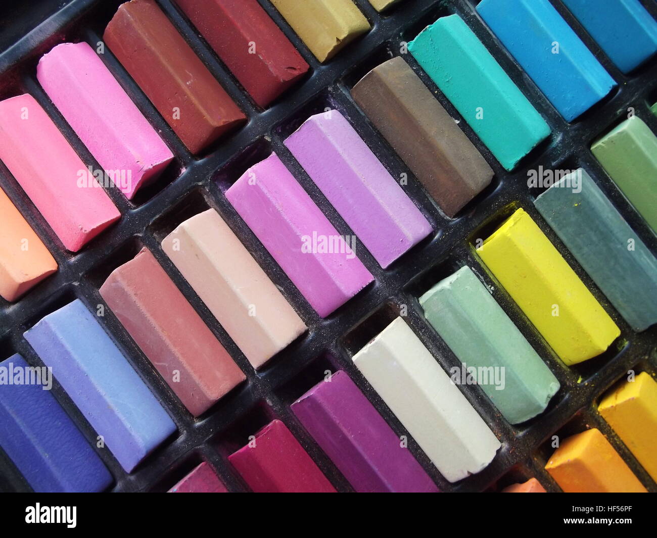 Rangées de bâtons de craie de couleur disposés en diagonale en noir porte-sectionné Banque D'Images