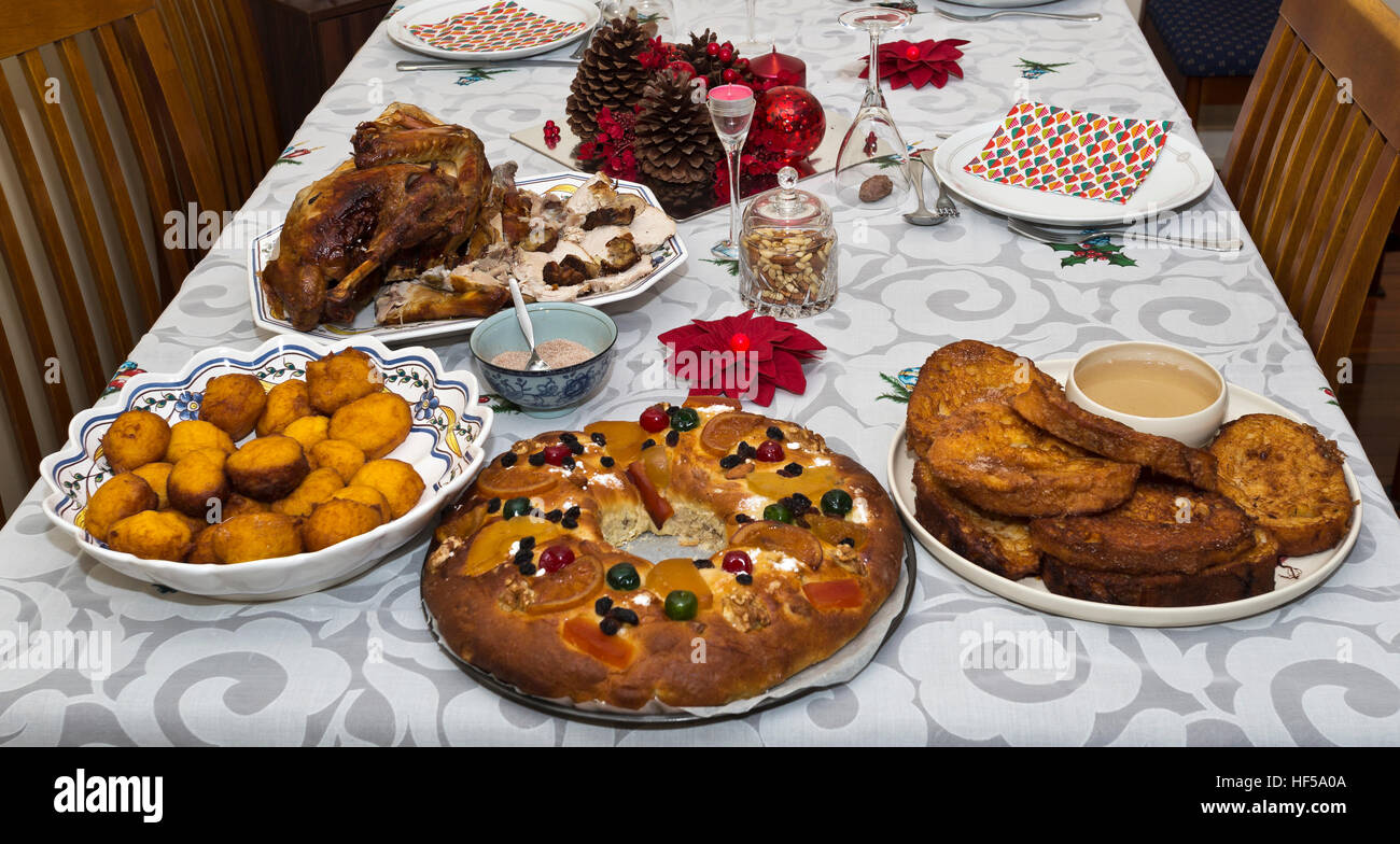 Tableau en partie établi pour une nuit de Noël traditionnels portugais avec dîner rôti de dinde et de desserts comme les beignets de citrouille, gâteau et rabanada Banque D'Images