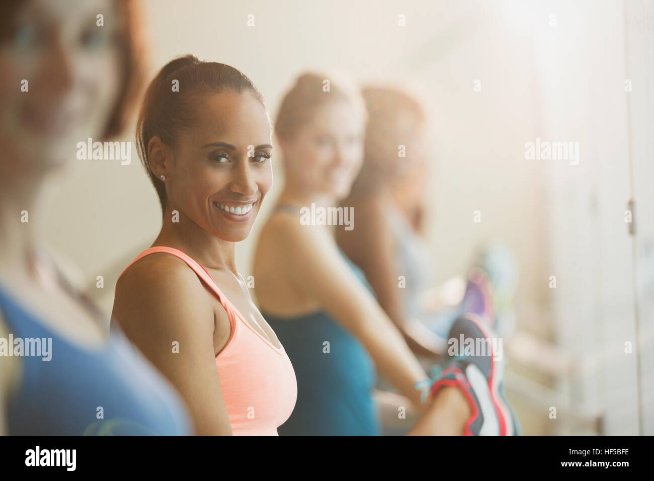 Portrait smiling women stretching jambes à barre en classe d'exercice fitness studio Banque D'Images