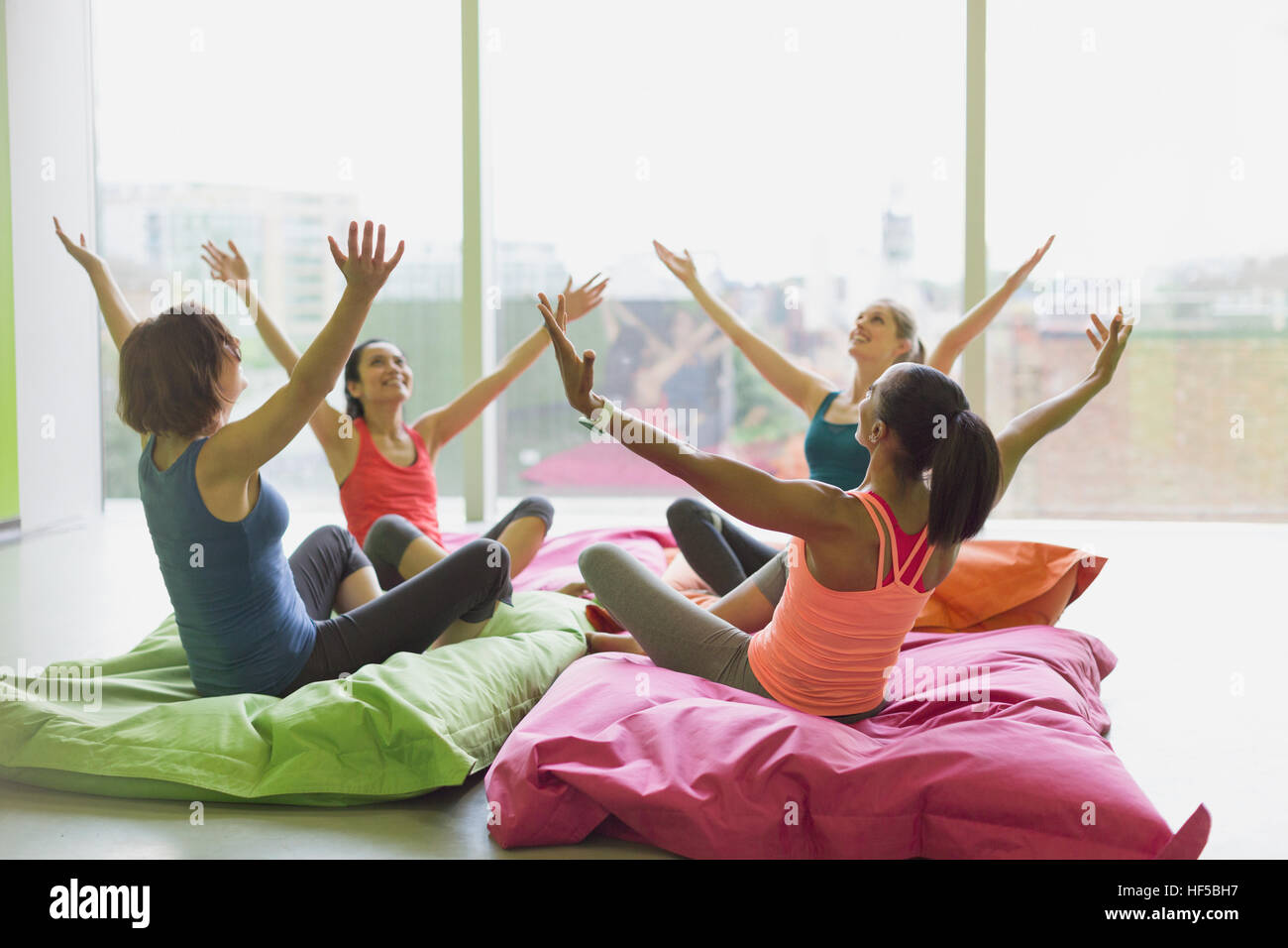 Les femmes se penchant avec bras levés sur des coussins en classe d'exercice fitness studio Banque D'Images