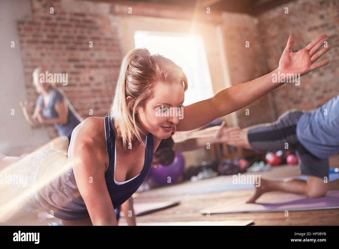 Young woman doing bird dog plank en classe d'exercice fitness studio Banque D'Images