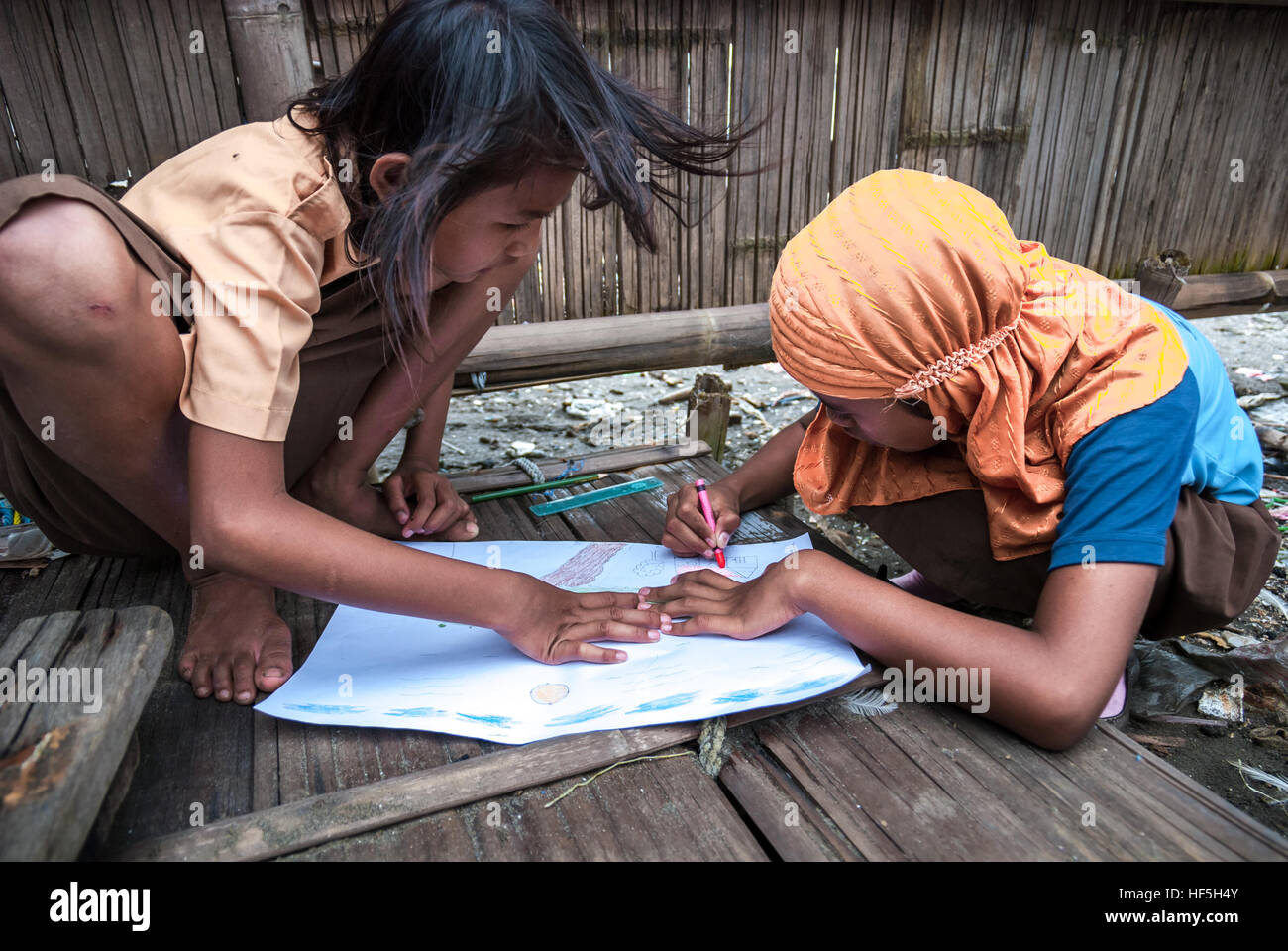 Des enfants dessinant une image de l'environnement à l'aide d'un crayon lors d'un événement de sensibilisation du public et de campagne dans le village de pêcheurs de Marunda à Jakarta, en Indonésie. Banque D'Images