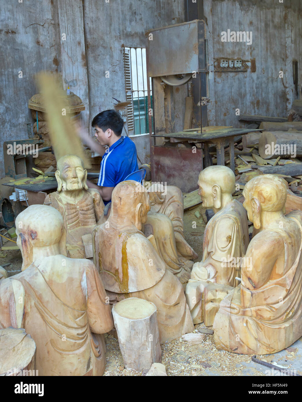 Jeune artisan travaillant, sculptures de Bouddha dans différentes positions. Banque D'Images