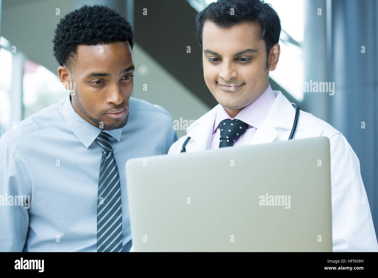Closeup portrait du professionnel de santé intellectuelle avec blanc labcoat, dossier du patient, à discuter les résultats avec le patient, à l'aide de digita Banque D'Images