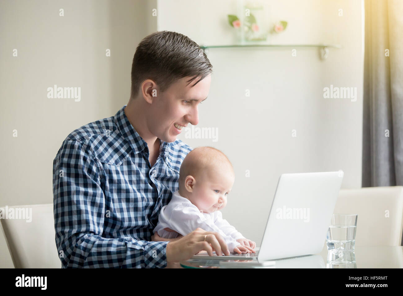 L'homme et un bébé à travailler à l'ordinateur portable Banque D'Images