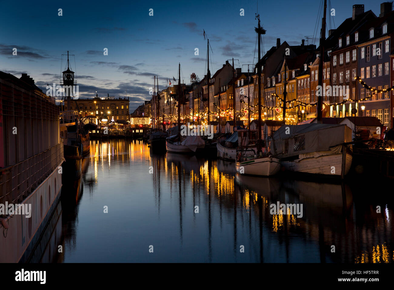 Danemark, copenhague, Nyhavn, hiver, bateaux amarrés au quai de nuit, reflétée dans l'eau Banque D'Images