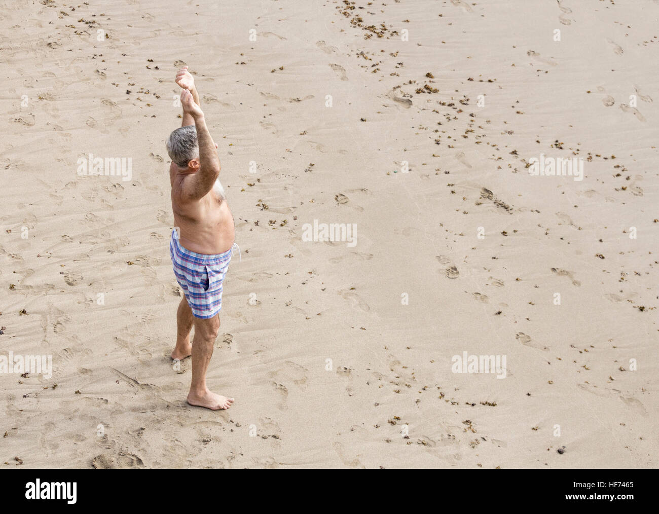 Un homme âgé qui s'étend sur la plage Banque D'Images