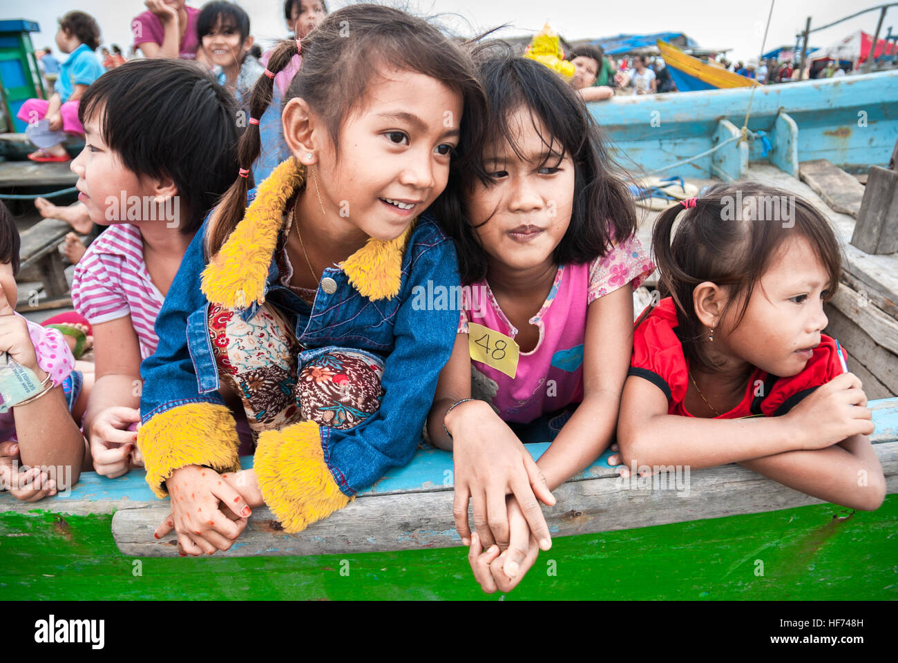 Enfants jouant sur des bateaux de pêche dans la zone côtière intertidale lors d'un événement de sensibilisation à l'environnement dans le village de pêcheurs de Marunda, Jakarta, Indonésie. Banque D'Images