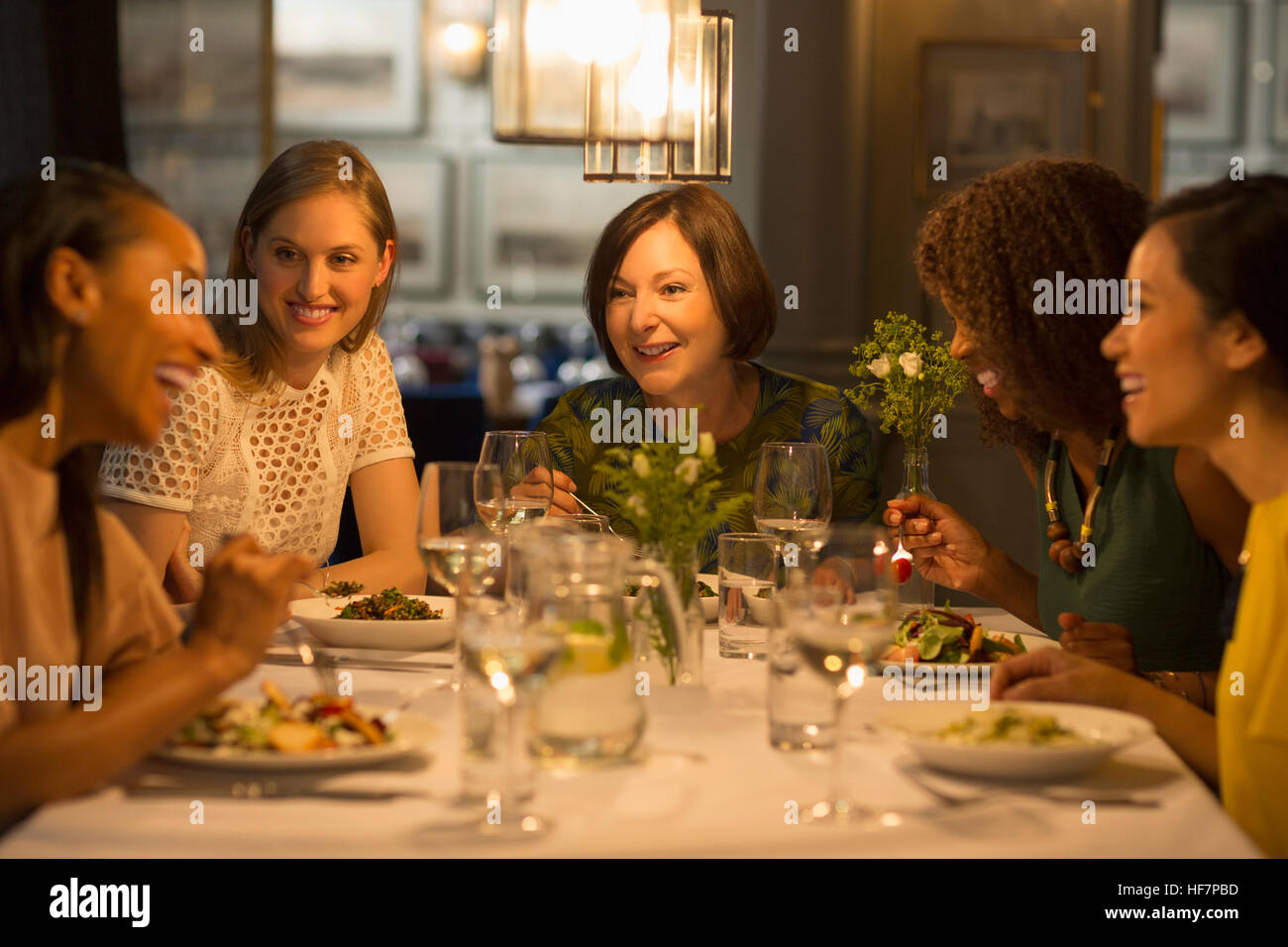 Smiling women friends dîner au restaurant table Banque D'Images