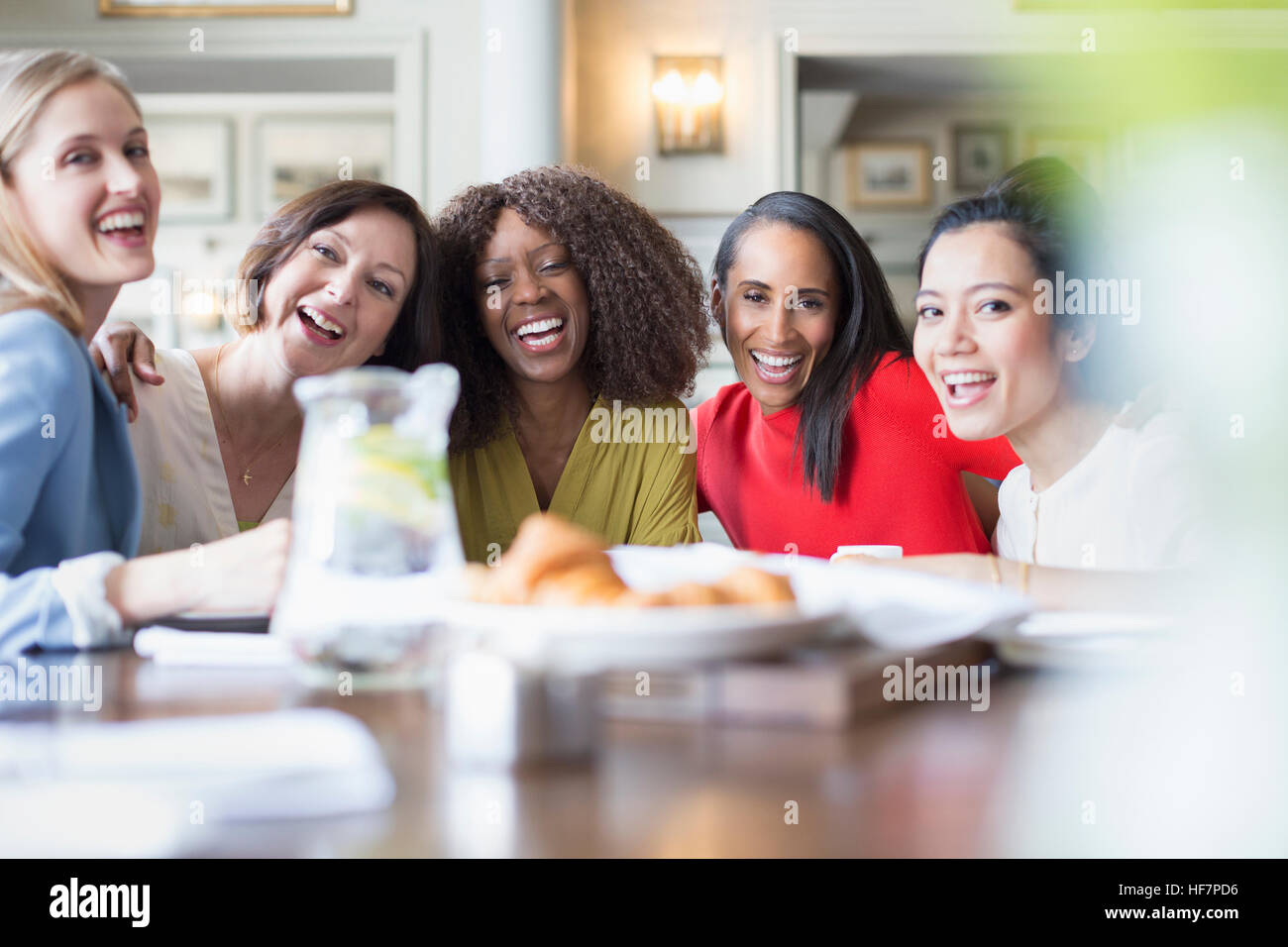 Portrait de rire amis des femmes à manger table restaurant Banque D'Images