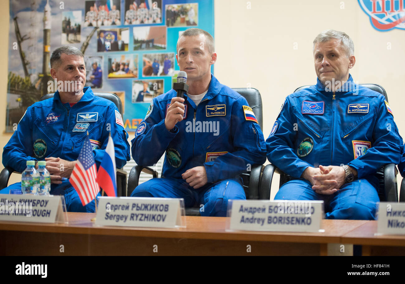 Expedition 49 commandant de Soyouz Sergey Ryzhikov, centre, répond à une quête de l'équipage au cours d'une conférence de presse, que ses coéquipiers du mécanicien de Shane Kimbrough de NASA, à gauche, et l'ingénieur de vol Andrey Borisenko de Roscosmos, droite, regard sur, alors que dans la zone de quarantaine derrière une vitre, le Mardi, Octobre 18, 2016 à l'hôtel cosmonaute à Baïkonour, au Kazakhstan. Kimbrough, Ryzhikov, et Borisenko sont prévues pour le lancement de la Station spatiale internationale à bord du vaisseau Soyouz MS-02 depuis le cosmodrome de Baïkonour le 19 octobre. Banque D'Images