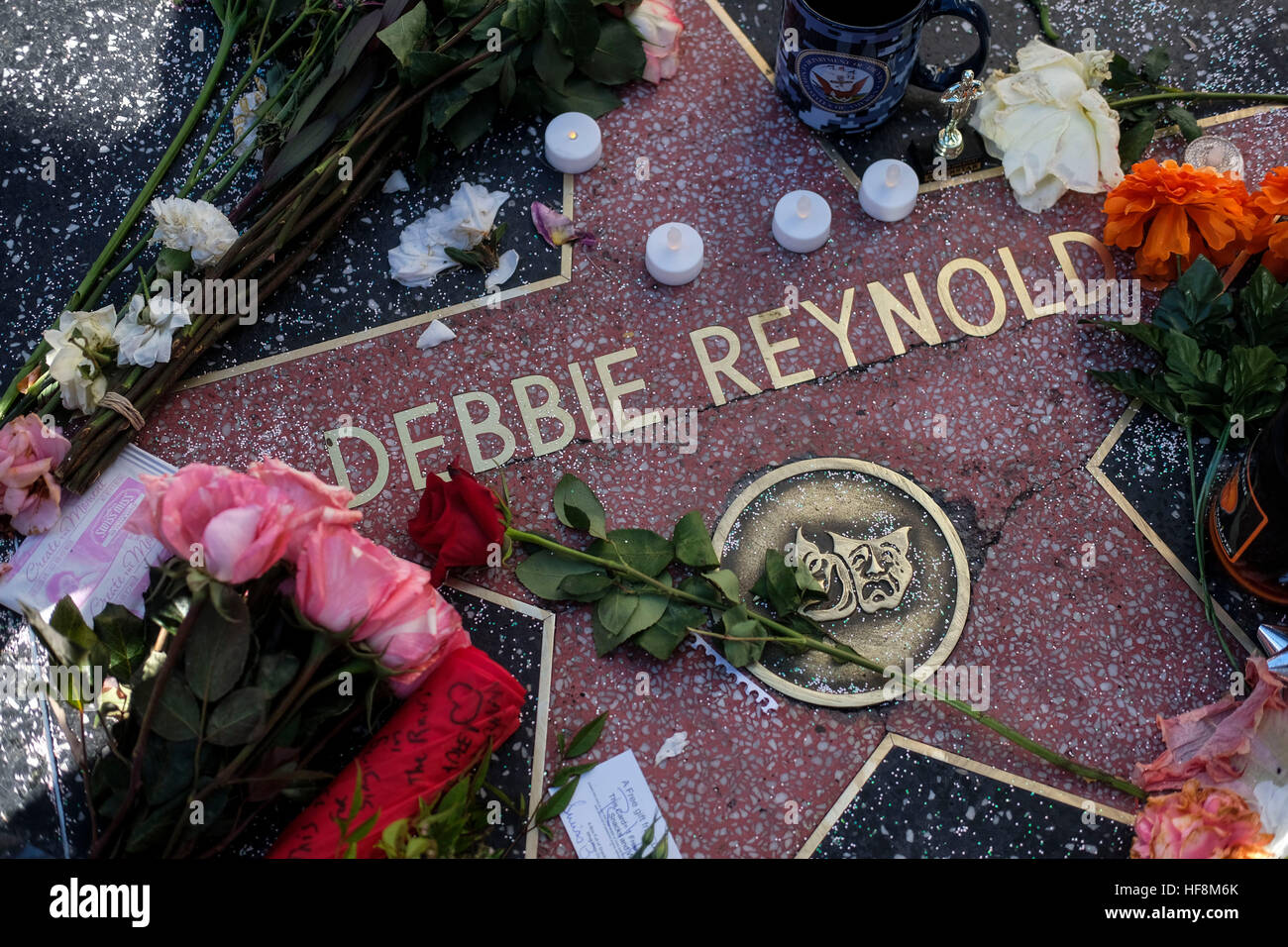 Los Angeles, USA. Dec 29, 2016. Des fleurs et des bougies entourent le Hollywood Walk of Fame star de Debbie Reynolds, à Los Angeles, Californie, États-Unis, le 29 décembre 2016. Hollywood star Debbie Reynolds est mort de course mercredi à l'âge de 84 ans, un jour après sa fille Carrie Fisher, la mort. L'actrice Carrie Fisher, mieux connue comme la princesse Leia dans La Guerre des étoiles, film de franchise, est mort à l'âge de 60 ans le mardi matin, après avoir subi une crise cardiaque sur un vol vendredi dernier. © Zhao Hanrong/Xinhua/Alamy Live News Banque D'Images