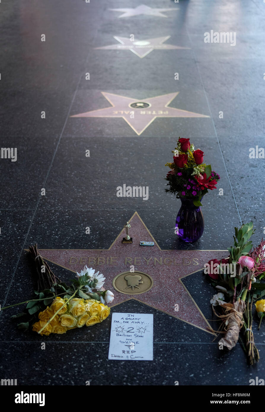 Los Angeles, USA. Dec 29, 2016. Des fleurs et des bougies entourent le Hollywood Walk of Fame star de Debbie Reynolds, à Los Angeles, Californie, États-Unis, le 29 décembre 2016. Hollywood star Debbie Reynolds est mort de course mercredi à l'âge de 84 ans, un jour après sa fille Carrie Fisher, la mort. L'actrice Carrie Fisher, mieux connue comme la princesse Leia dans La Guerre des étoiles, film de franchise, est mort à l'âge de 60 ans le mardi matin, après avoir subi une crise cardiaque sur un vol vendredi dernier. © Zhao Hanrong/Xinhua/Alamy Live News Banque D'Images
