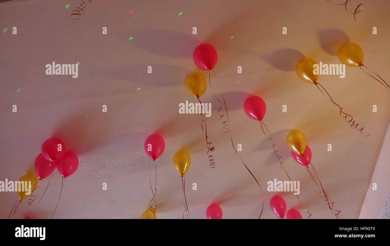 Ballons jaunes rouge accroché au plafond de maison de vacances Banque D'Images
