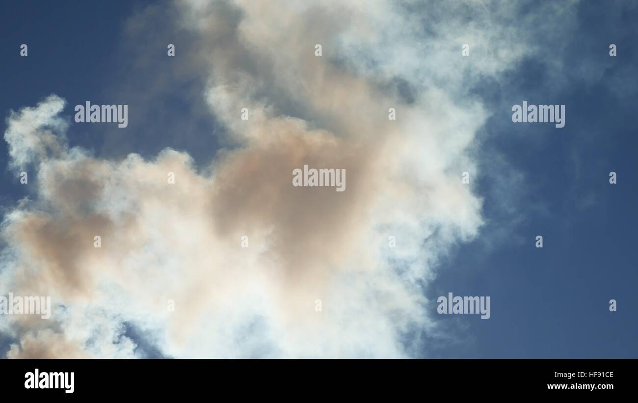 La fumée blanche contre un nuage bleu ciel soleil paysage nature Banque D'Images