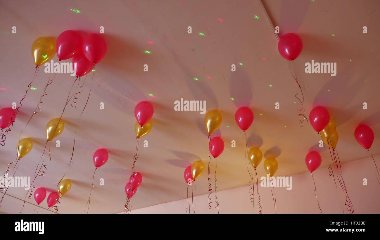 Ballons rouges suspendus au plafond jaune de vacances Banque D'Images