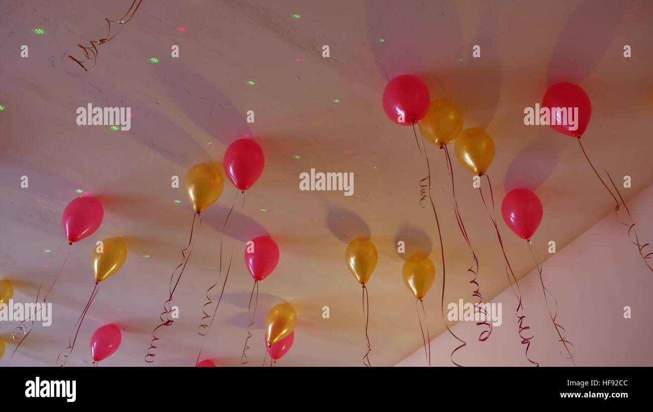 Ballons jaunes rouge accroché au plafond de la maison de vacances Banque D'Images
