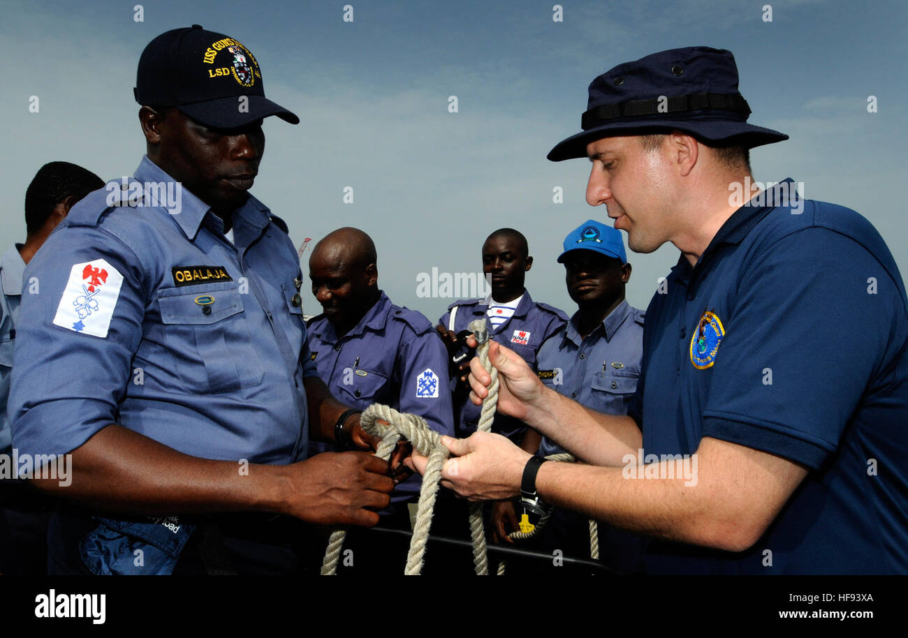 La Garde côtière des États-Unis l'Adjudant-chef 3 Earl Schlemmer, un partenariat de l'Afrique centrale (APS) à l'Ouest, de l'instructeur de la marine nigériane montre maître de Ademola Obalaja bonne fabrication de nœuds techniques pendant une opération de base petit bateau à bord d'un atelier à coque rigide à Sekondi, Ghana, le 15 mars 2010. L'APS est une initiative multinationale élaborées par la U.S. Naval Forces Europe/Afrique pour travailler avec les États-Unis et les partenaires internationaux pour renforcer la sécurité maritime et de la sécurité sur le continent de l'Afrique. (Photo du département de la communication de masse en 1ère classe Spécialiste Martine Cuaron, U.S. Navy/libérés) 100315-N-7948 Banque D'Images
