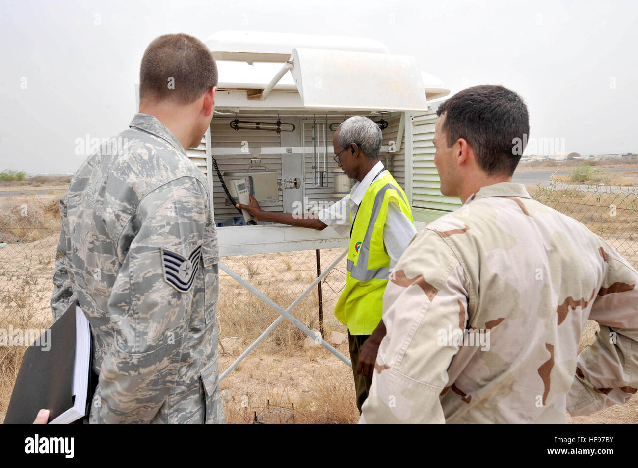 M. Said Darar, chef de données climatologiques pour Djibouti, spectacles U.S. Air Force Tech. Le Sgt. David Giddens et de la Marine Le Lieutenant Cmdr. Ricardo Trevino instruments à la prévision météorologique de l'Aéroport International Ambouli à Djibouti, le 5 septembre. Giddens, membre de la Garde nationale aérienne de Washington et originaire de Jacksonville, en Floride, et Trevino, chef de la Force opérationnelle combinée de Force-Horn météorologiques et océanographiques de l'Afrique Ministère et natif de Bayamon, Puerto Rico, étaient à l'aéroport d'installer une ligne à haute fréquence de visée l'antenne qui vous permettra de recevoir des prévisions météorologiques djiboutienne a s Banque D'Images