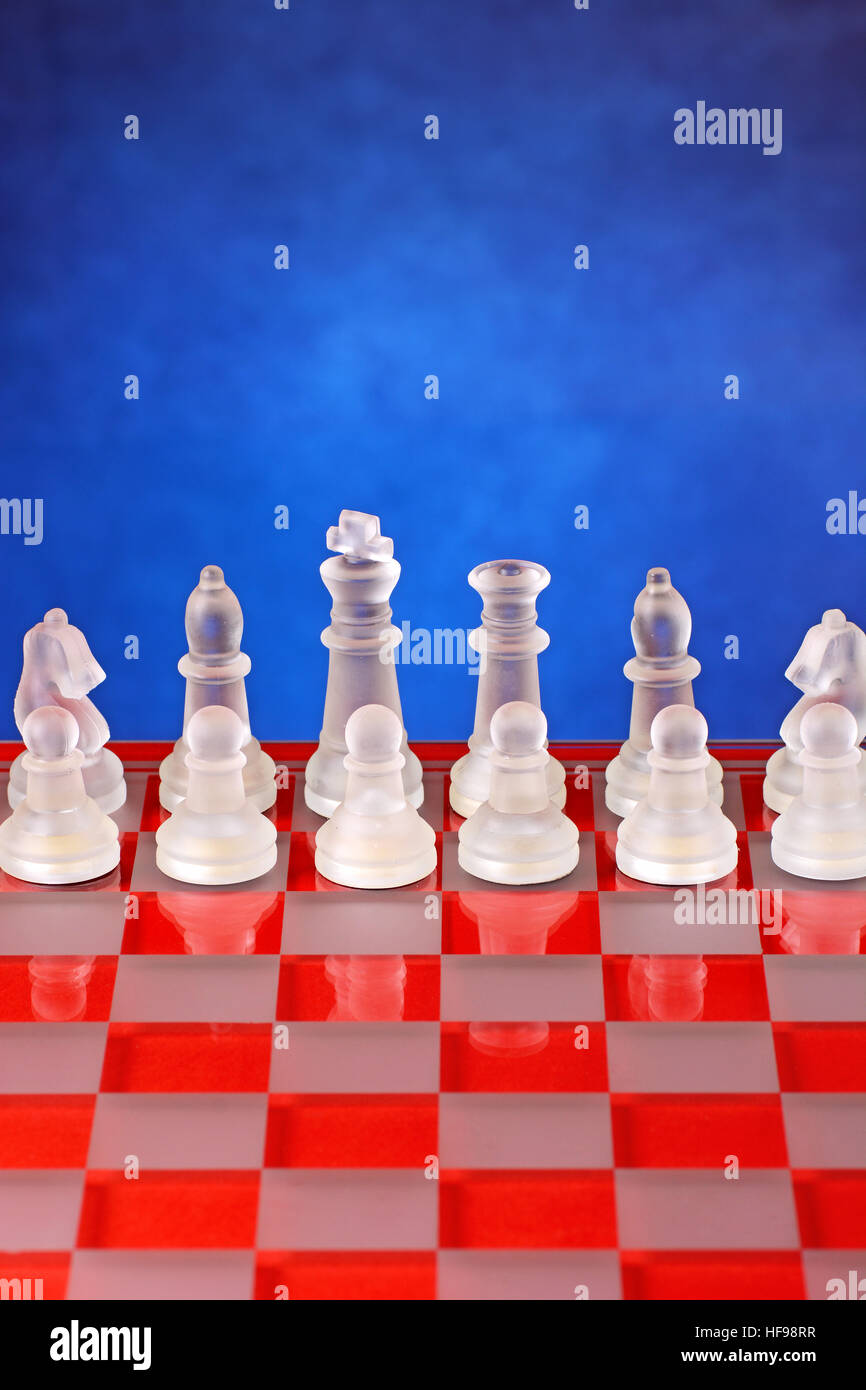 D'échecs en verre sur l'échiquier - Fond bleu Banque D'Images