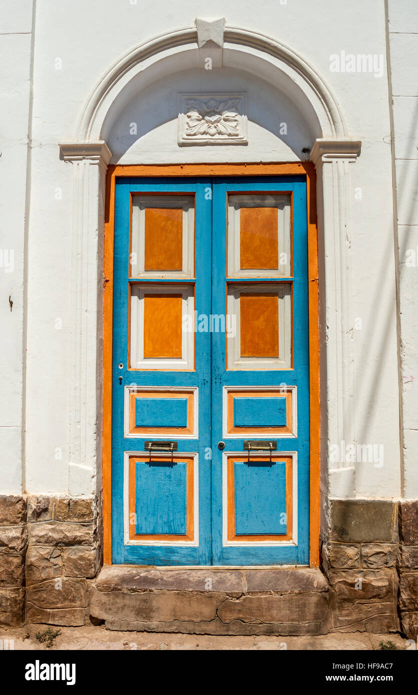 Ancien bleu et orange porte dans l'épluchage maison murs Banque D'Images