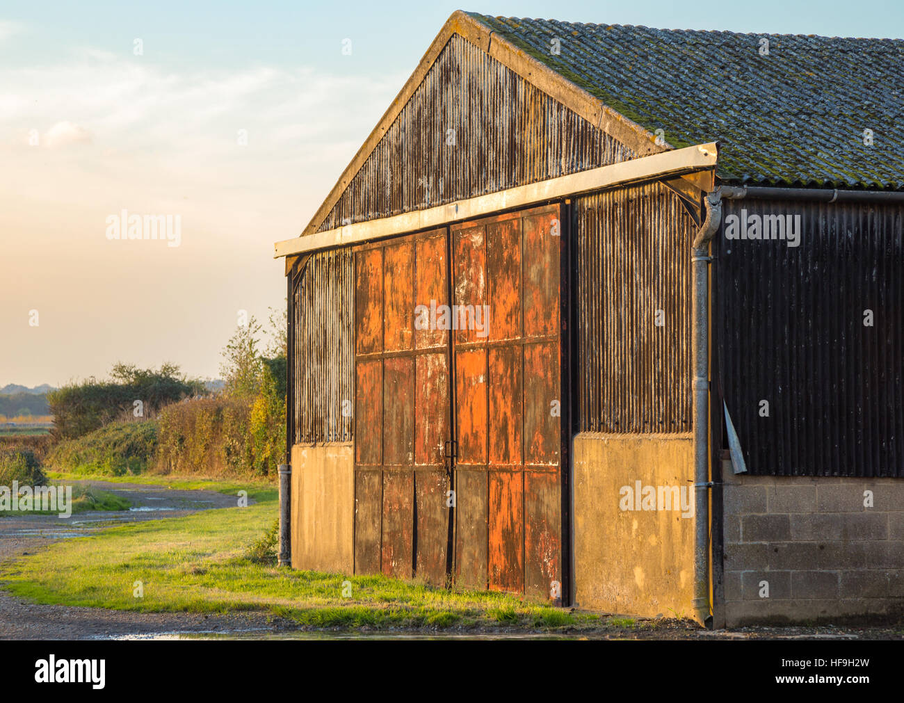 Grange est sur les terres agricoles près du village d'abréger dans Essex, par un beau jour d'automne. Belle et rouge portes rouillées. Banque D'Images