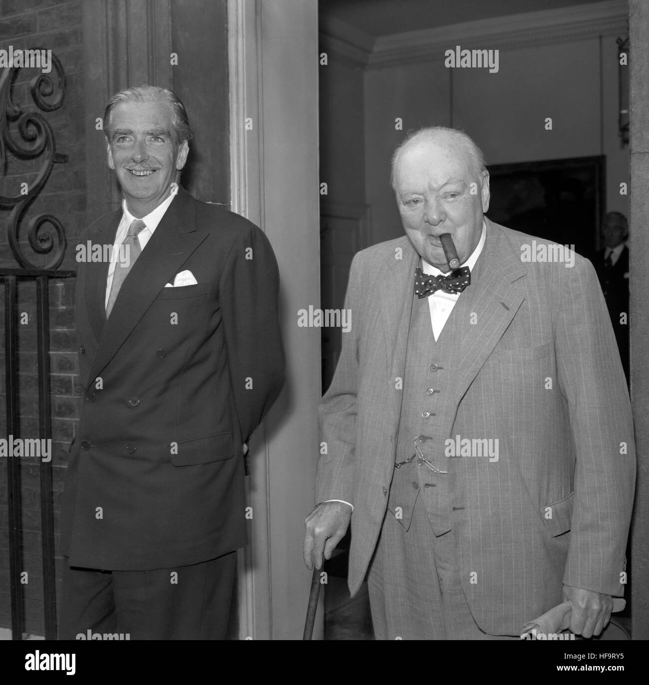 Le premier ministre, Sir Anthony Eden sourire alors qu'il vient à la porte de l'au 10, Downing Street, Londres, avec Sir Winston Churchill, son prédécesseur, après leur réunion. Banque D'Images