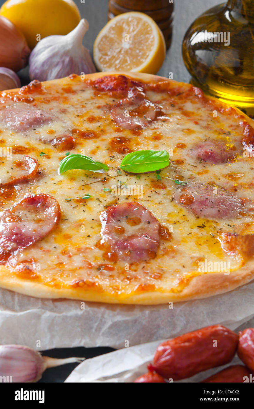 Délicieux fromage salami pizza avec des ingrédients à côté Banque D'Images