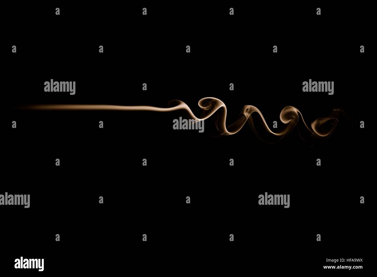 Vague fumée or isolé sur noir. Vague de fumée horizontale. Traînée de fumée. Banque D'Images