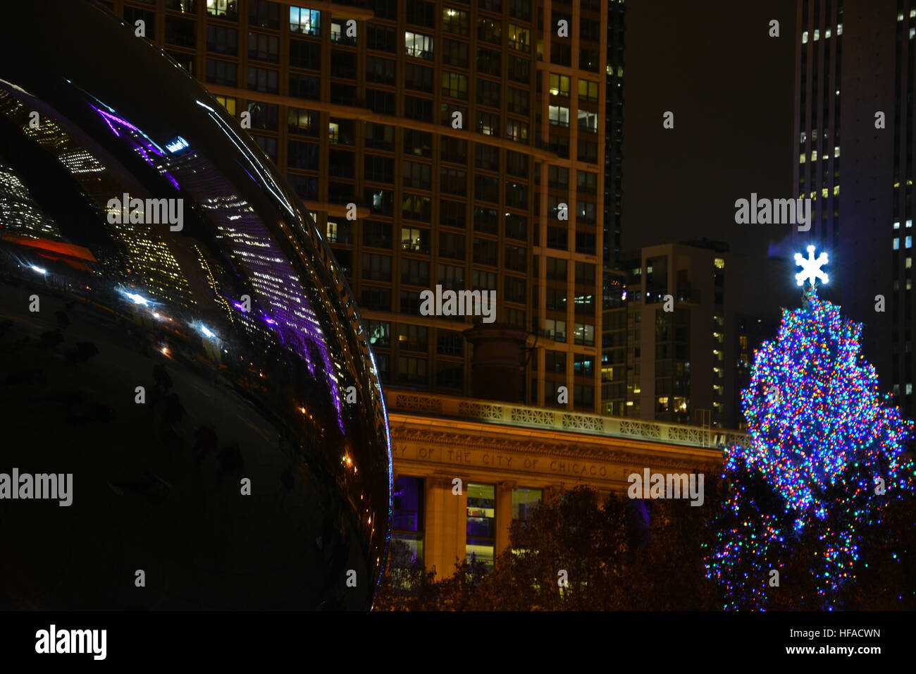 Cloud Gate, aussi connu sous le nom de "Bean" reflète la nuit skyline entourant le parc du Millénaire pendant les vacances. Banque D'Images Cloud Gate, aussi connu sous le nom de "Bean" reflète la nuit skyline entourant le parc du Millénaire pendant les vacances. Banque D'Images