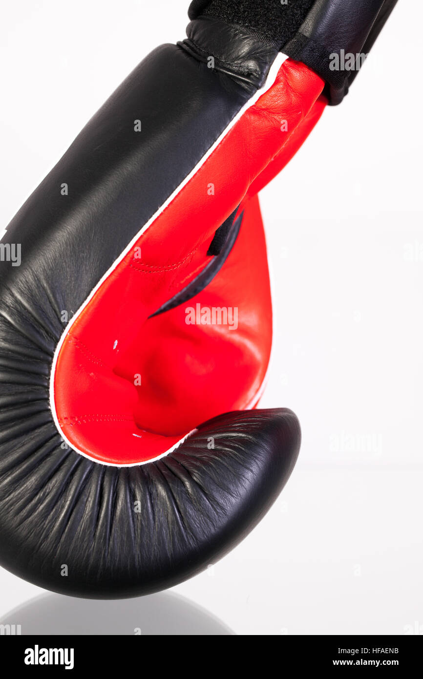 Gants de boxe rouge et noir sur une table en verre isolé sur fond blanc Banque D'Images